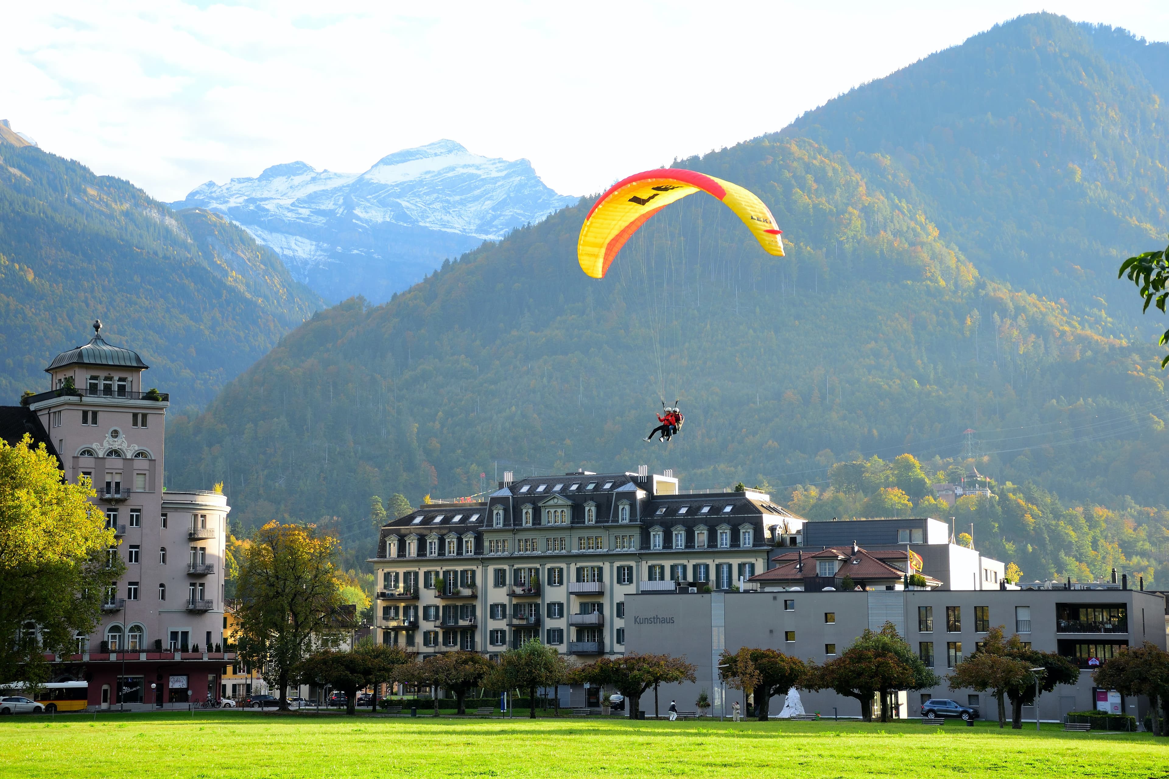 Paragliders soaring above Interlaken with mountain backdrop